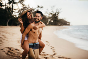Elopement & Family Photography, man carries woman on back on the tropical beach near shore