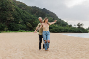Couples Photographer, man and woman playfully walk on beach together